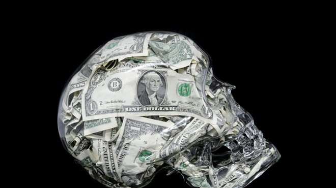 A glass skull filled with U.S. dollars
