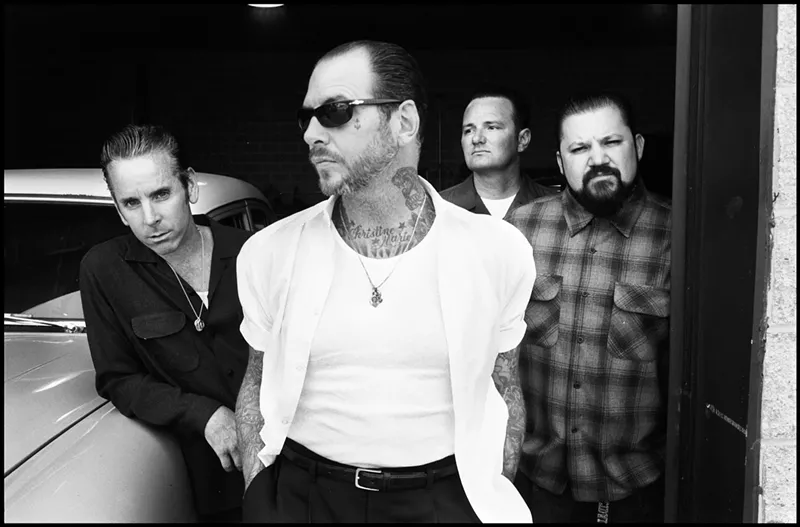Image: Black and white image of the four members of the punk band Social Distortion