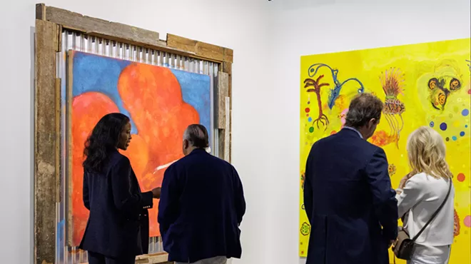 people view colorful artworks inside a gallery