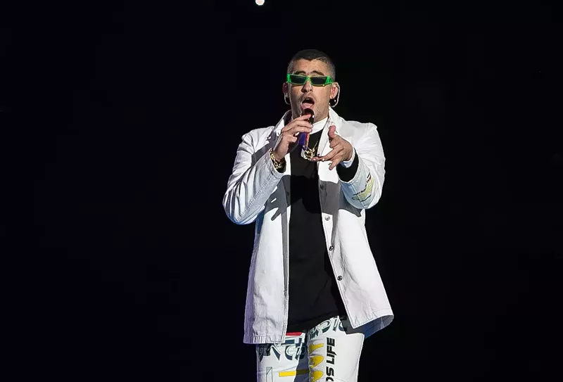 Image: A man dressed in white holding a microphone