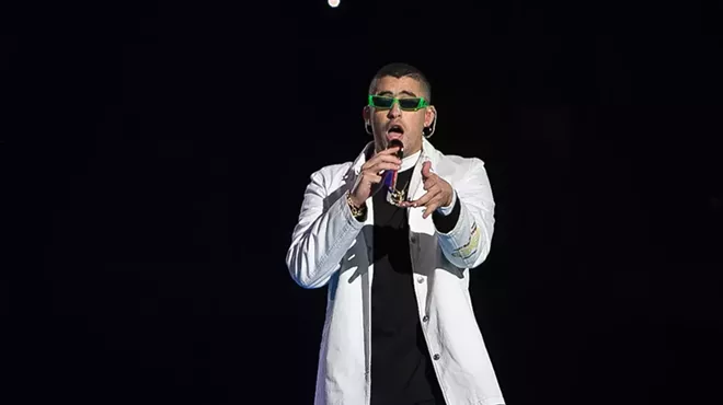 A man dressed in white holding a microphone