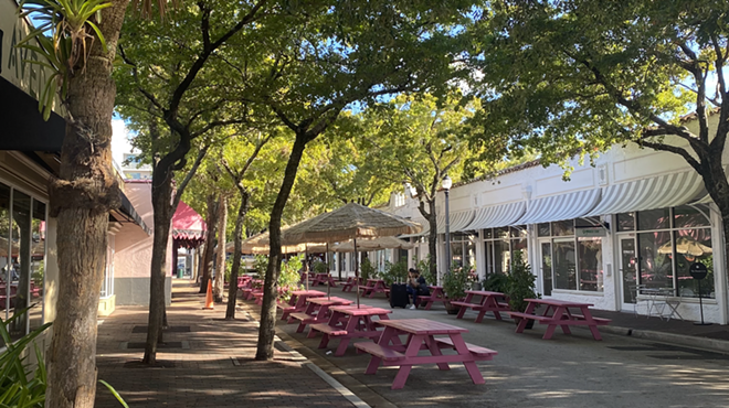 An empty street with pink picnic seating