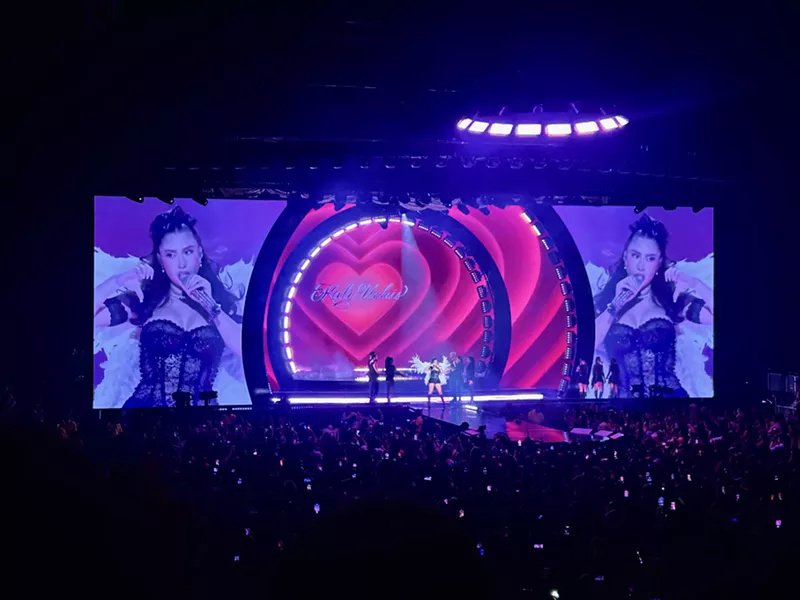 Image: Picture of Kali Uchis singing on stage in front of a screen projecting a heart.