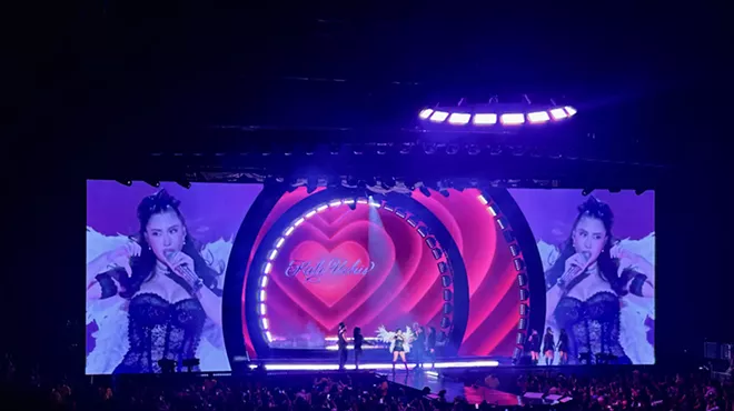 Picture of Kali Uchis singing on stage in front of a screen projecting a heart.