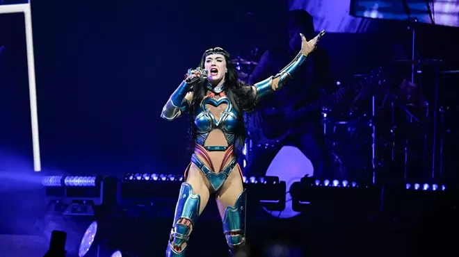 Katy Perry singing on stage, wearing a chrome suit.