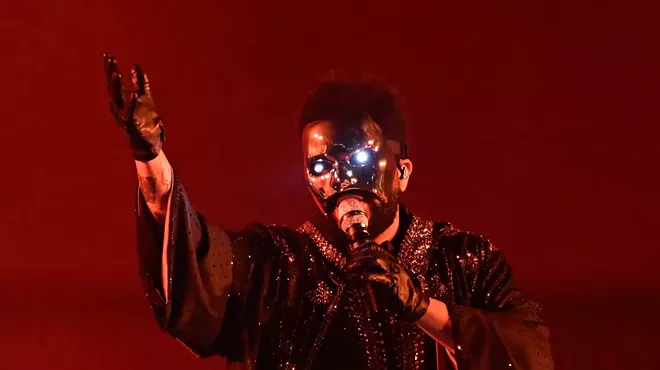 Artist the Weeknd performing with a mask.