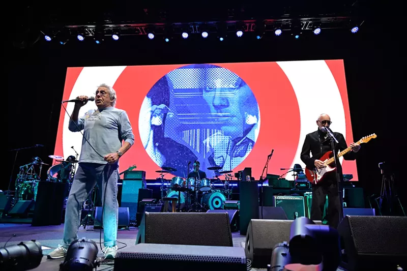 Image: The Who band playing on stage.