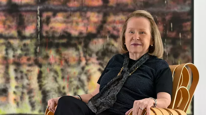Rosa de la Cruz seated in front of a large painting
