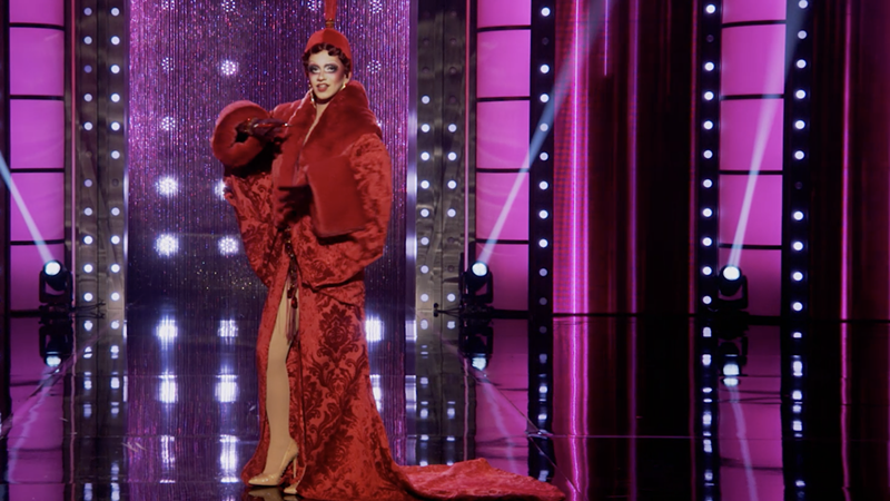 Image: drag queen suzie toot wears a long red cocoon coat