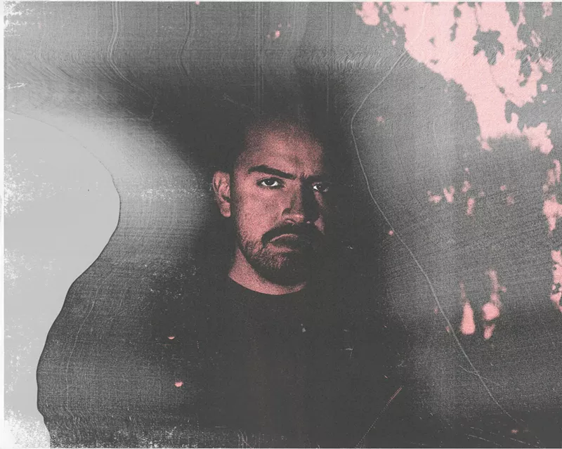 Image: Portrait of a man against a black and pink backround