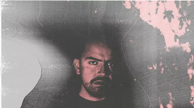 Portrait of a man against a black and pink backround