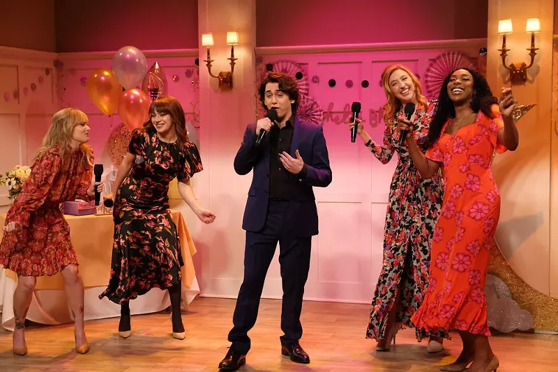 Image: four women surround a man singing at a reception