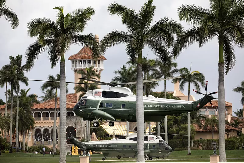 Image: Then-President Donald Trump aboard Marine One lands back at Mar-a-Lago as an escort helicopter hovers Friday, March 29, 2019.