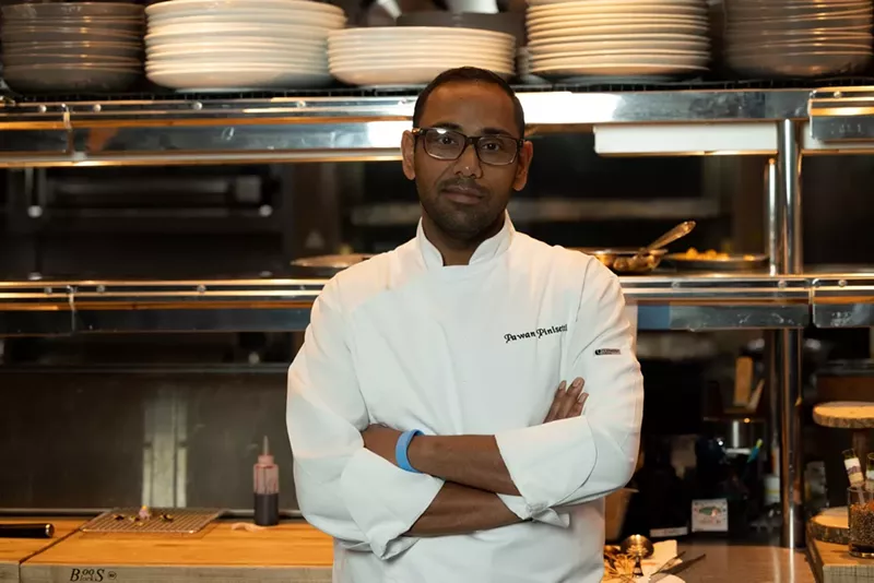 Image: A chef in a white chef outfit posing