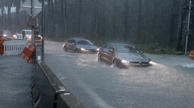 Vehicles make their way through a flooded street on June 12, 2024, in Aventura, Florida, as tropical moisture passes through the area.