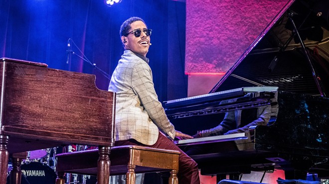 Matthew Whitaker plays the piano on stage