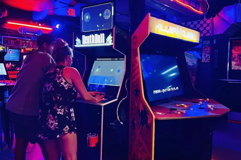 Image: A couple playing an arcade game at Glitch Bar in Fort Lauderdale
