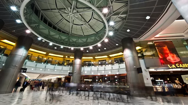 A long exposure of people walking through the gates of Miami International Airport