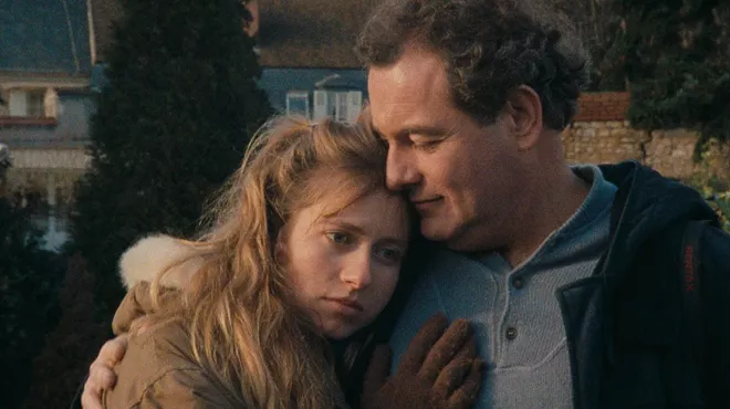 film still shows a woman and man hugging