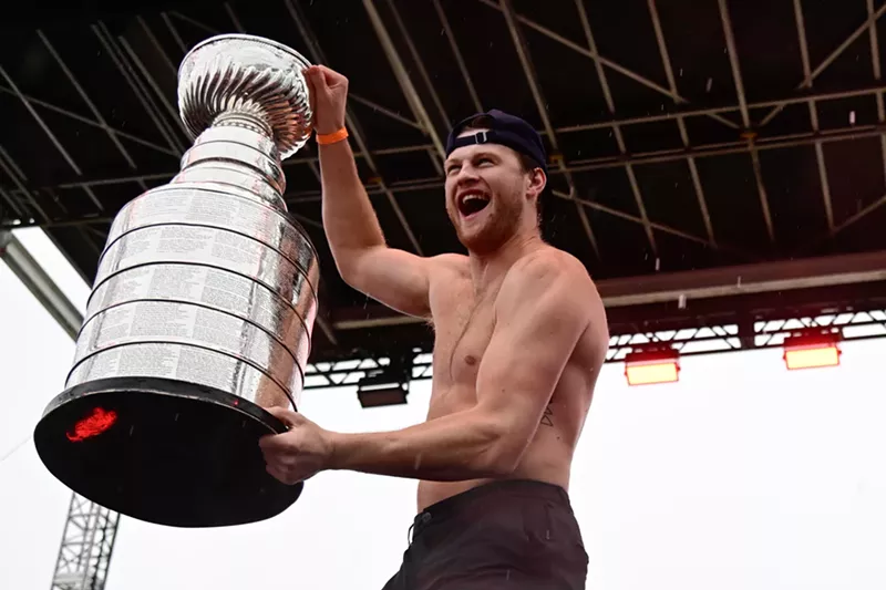 Image: A shirtless Steven Lorentz holding the Stanley Cup trophy