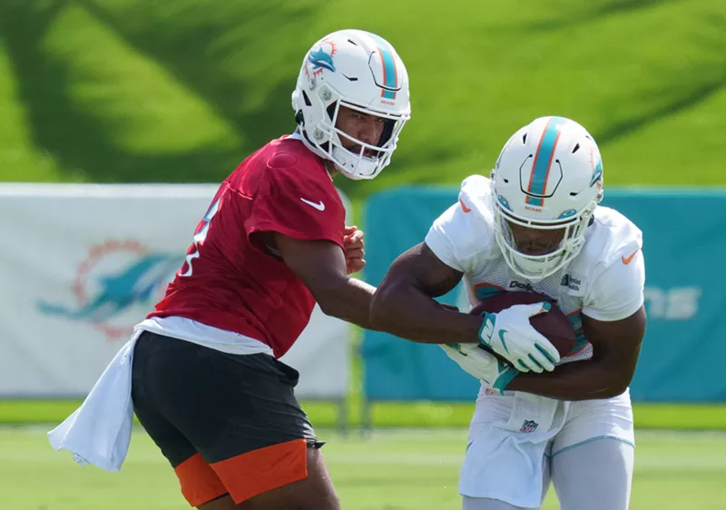 Image: Tua Tagovailoa handing off to Salvon Ahmed during Miami Dolphins training camp in 2021