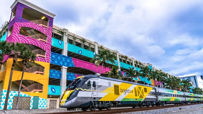 Brightline train in front of colorful parking garage in West Palm Beach
