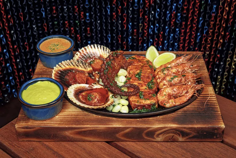 Image: A dish of seafood and a green dip on a wooden table