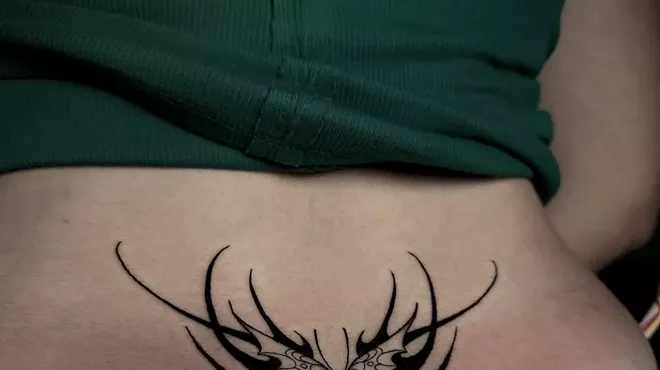 Woman with a tribal style lower back tattoo