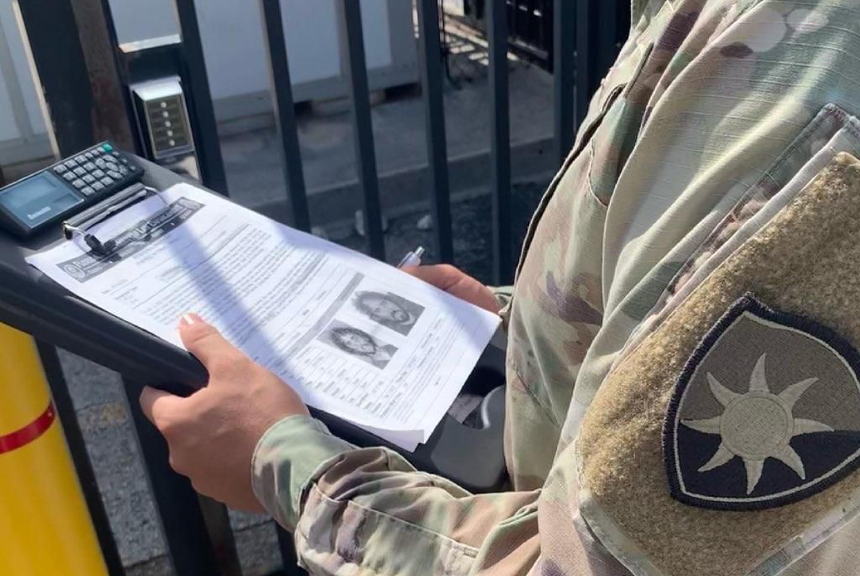 A military officer reviews a FDLE file on activist Thomas Kennedy ahead of a Ron DeSantis press conference