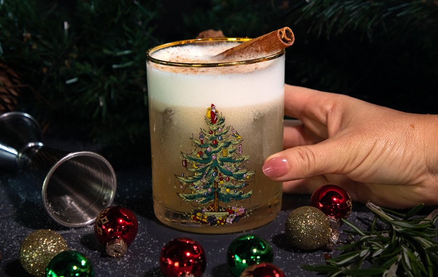 This cocktail from Whiskey Neat is served in a festive glass with a Christmas tree painted on the side
