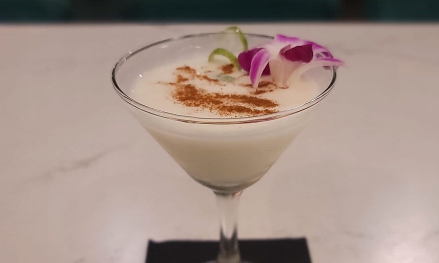 This coquito martini is served in a martini glass and topped with garnishes
