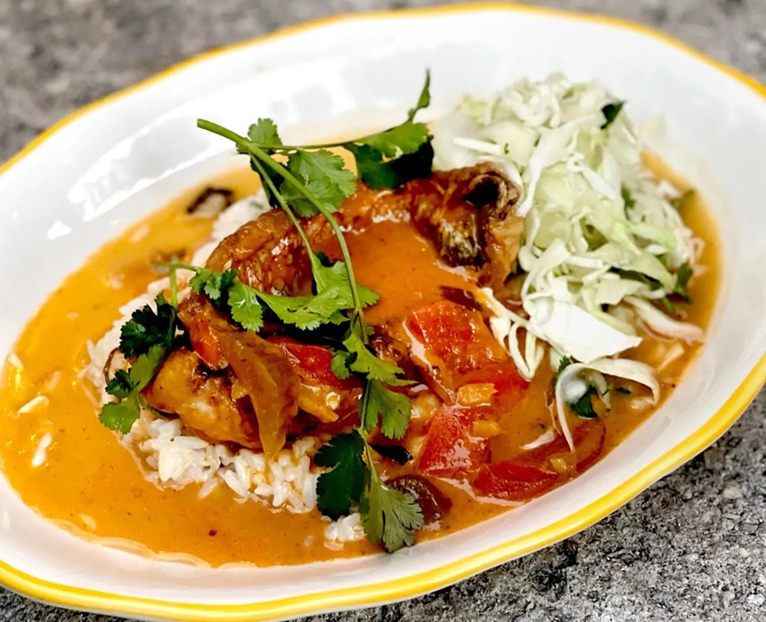 The Katherine's Thai Red Curry Yellowtail dish is plated on a bed of coconut rice and topped with fresh cilantro