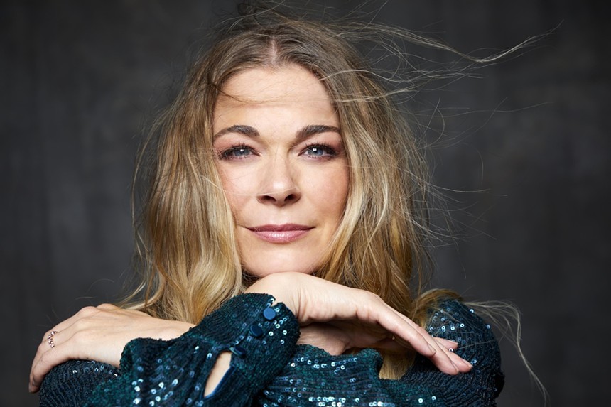 Singer LeAnn Rimes with her arms crossed wearing a blue sequined dress