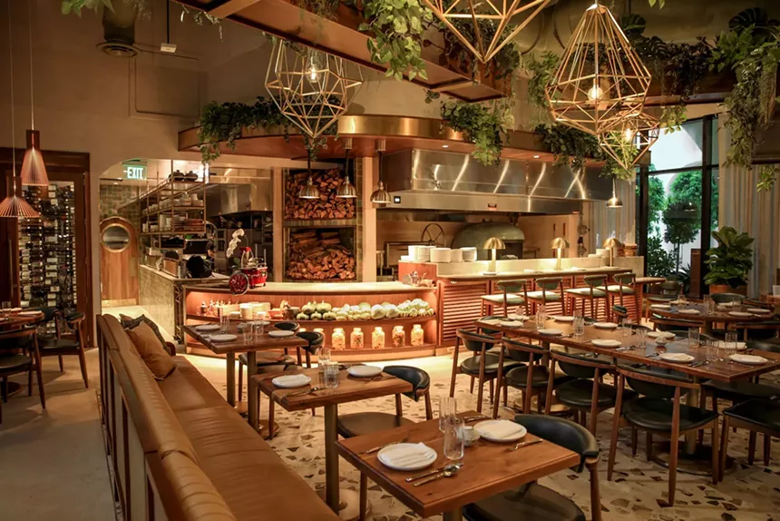 The dining room of a restaurant with hanging plants