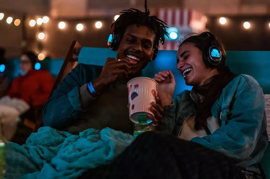 A couple sharing popcorn while laughing