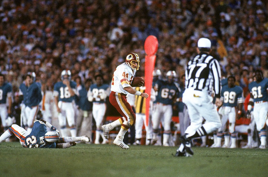 Vintage photo of NFL running back John Riggins dashing during 1983 Super Bowl