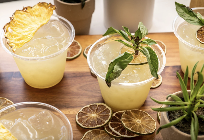 Yellow lemon pineapple drinks in plastic cups