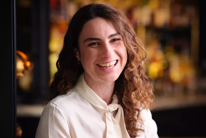 Headshot of Liana Oster in a white outfit.