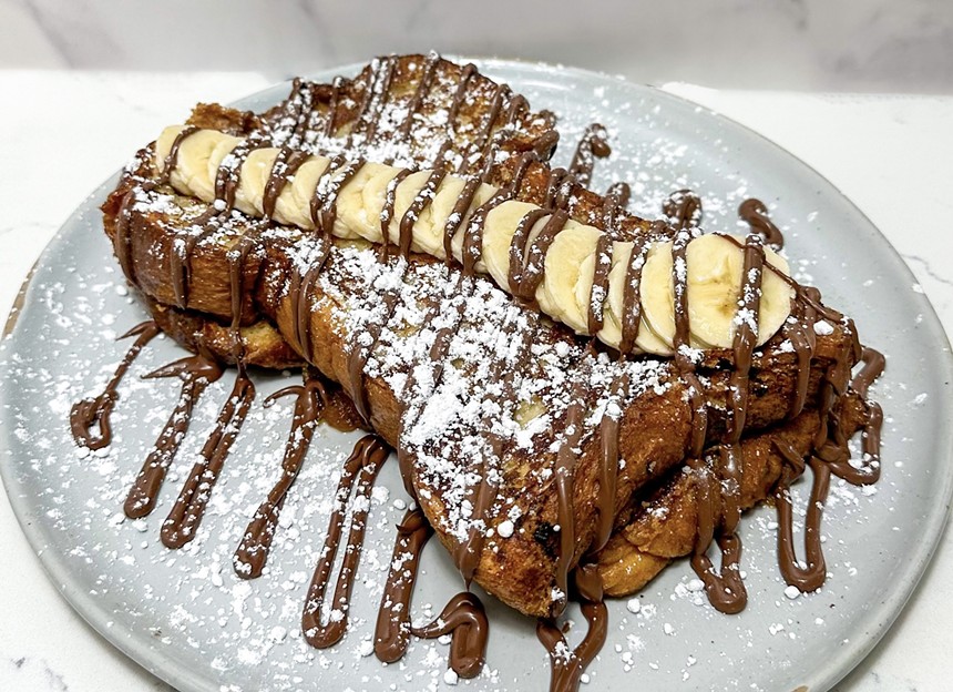 Nutella french toast topped with bananas and chocolate on a plate