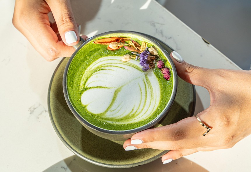 A green matcha latte with milk froth foam.