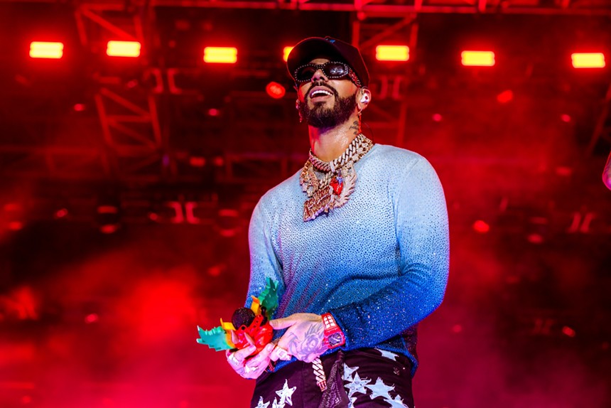 Anuel AA on stage in a blue ombre shirt