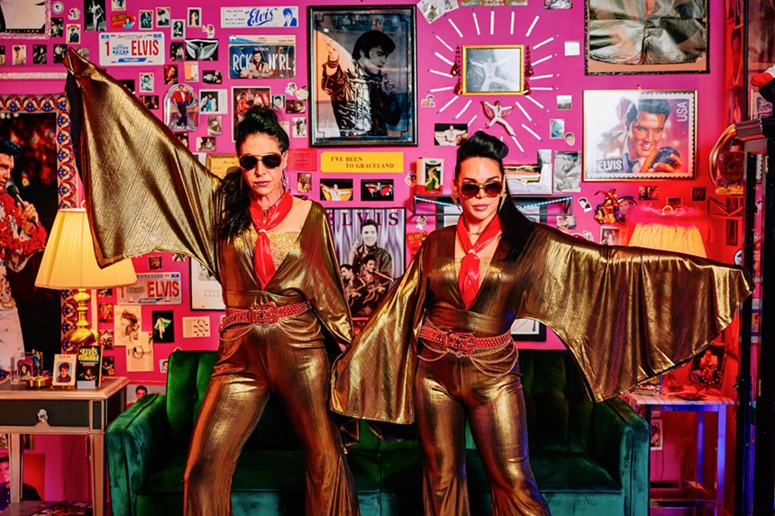 Susie K. Taylor and June Raven Romero in gold jumpsuits and sunglasses