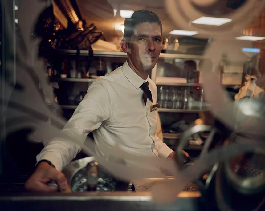 A male server inside the coffee window at Versailles in Miami