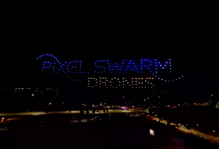 Drones spelling out Pixel Swarm Drones in the night sky