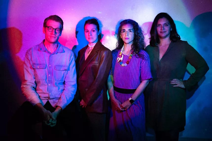 Tim Davis, Elizabeth Price, Vanessa Garcia, and Victoria Collado standing against a wall with color lights