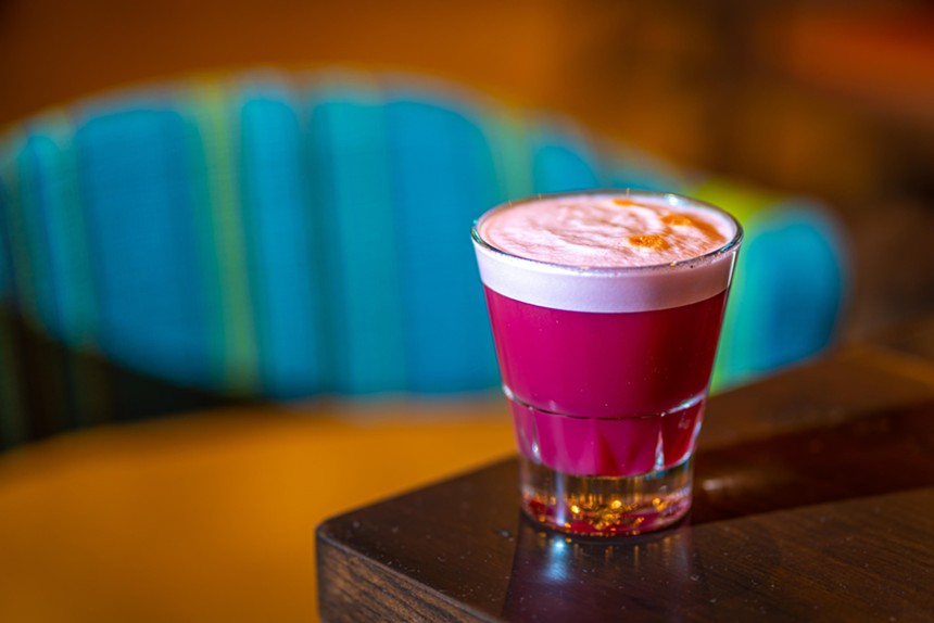 A purple cocktail with foam