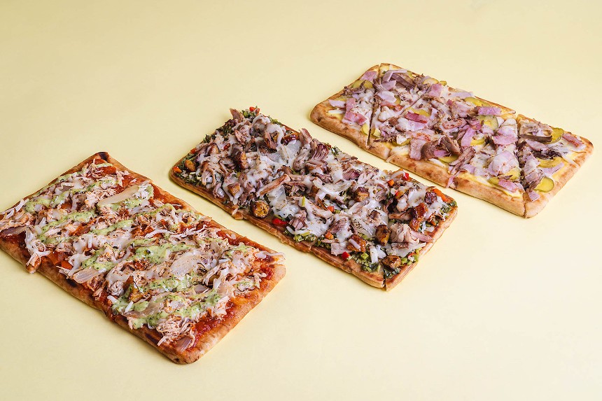 Three flatbreads on a yellow surface