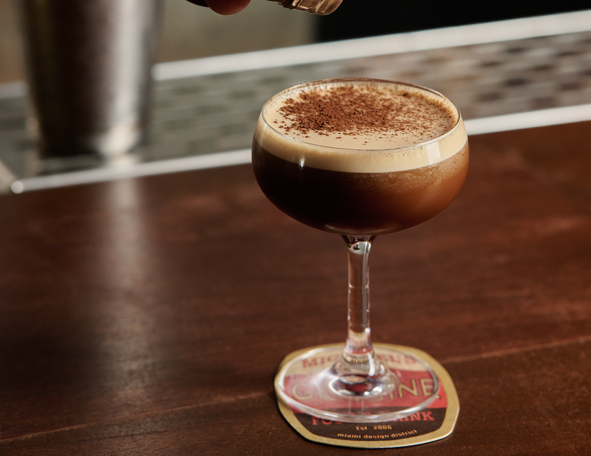 A brown cocktail with foam