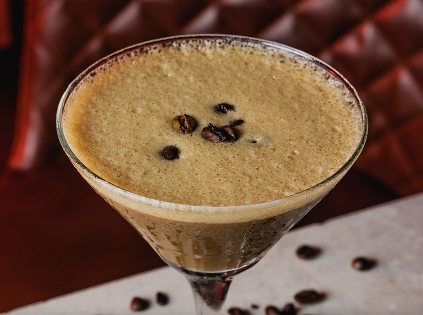A light brown cocktail with three beans as garnsih