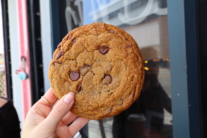 A chocolate chip cookie being held with one hand